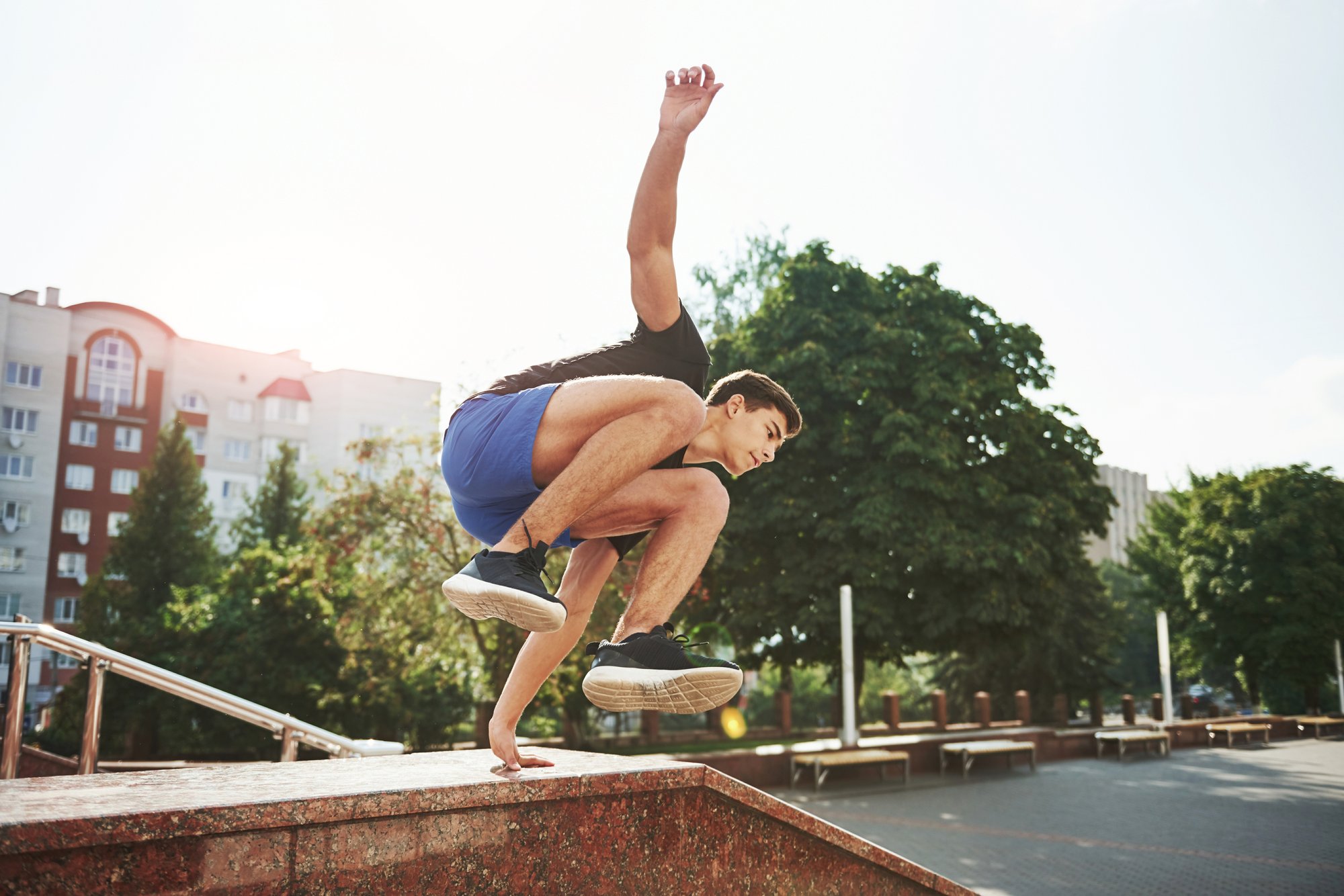 Man coming down from a jump over a staircase wall